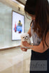 Person holding a small white dog in an indoor setting with a blurred background